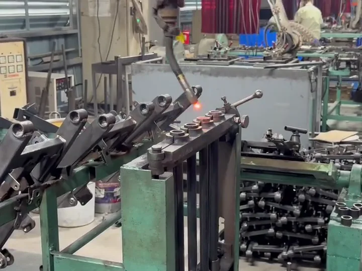 Robot đang hàn các chi tiết kim loại trên đồ gá